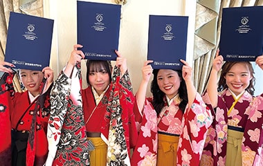卒業証書を掲げる学生たち